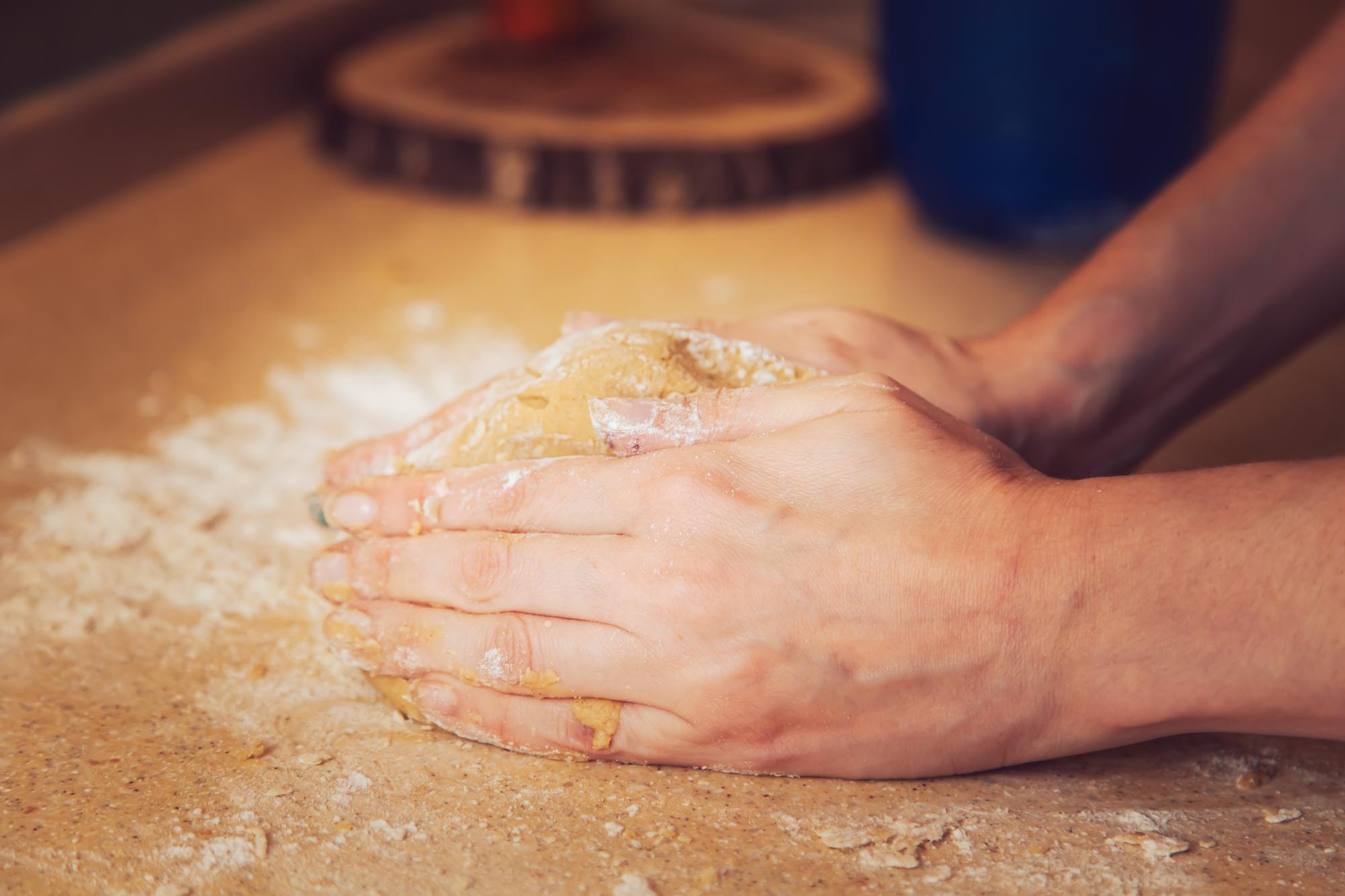 Hands kneading dough during class